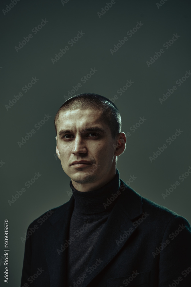 Fototapeta premium Serious handsome confident guy, security or businessman on gray background, studio male portrait with copy space
