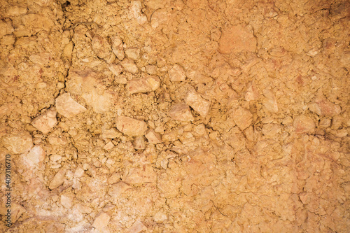 rocky dry ground with cracks of terracotta color, texture. 