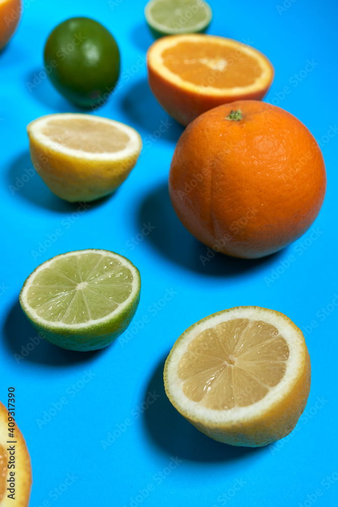 Whole and split oranges, limes and lemons with skin on a blue background. CITRUS CITRIC Whole and split oranges, limes and lemons with skin on a blue background. CITRUS CITRIC