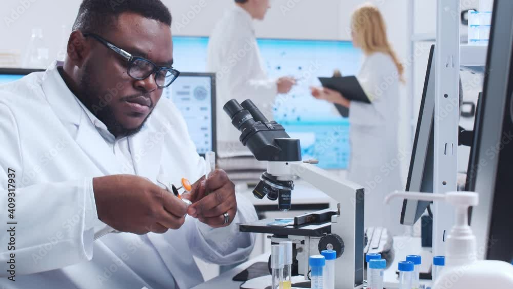 Professional team of scientists is working on a vaccine in a modern scientific research laboratory. Genetic engineer workplace. Futuristic technology and science concept. Professional team of scientists is working on a vaccine in a modern scientific research laboratory. Genetic engineer workplace. Futuristic technology and science concept.