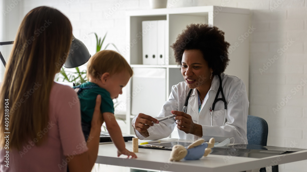 Female doctor pediatrician with baby patient and mother. Child development in first years Female doctor pediatrician with baby patient and mother. Child development in first years