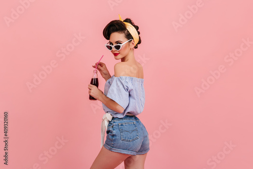Konstfotografi Slim pinup girl in denim shorts looking over shoulder