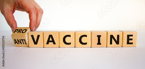 Pro-vaccine or anti-vaccine symbol. Doctor turns a cube, changes words 'anti-vaccine' to 'pro-vaccine'. Beautiful white background. Copy space. Medical covid-19 pro-vaccine or anti-vaccine concept. photo