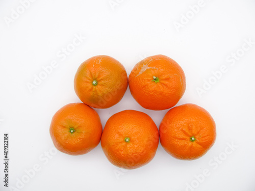 Five orange fresh tangerines on a white background. Top view.