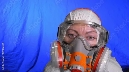 Scientist virologist in respirator. Slow motion. Woman close up look wearing protective medical mask. Concept health safety N1H1 virus protection coronavirus epidemic 2019 nCoV. Chroma key blue film. photo