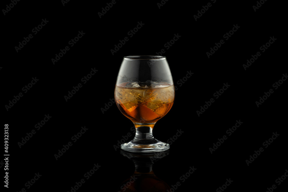 Glass of cognac with ice isolated on black background. Glass of cognac with ice isolated on black background.