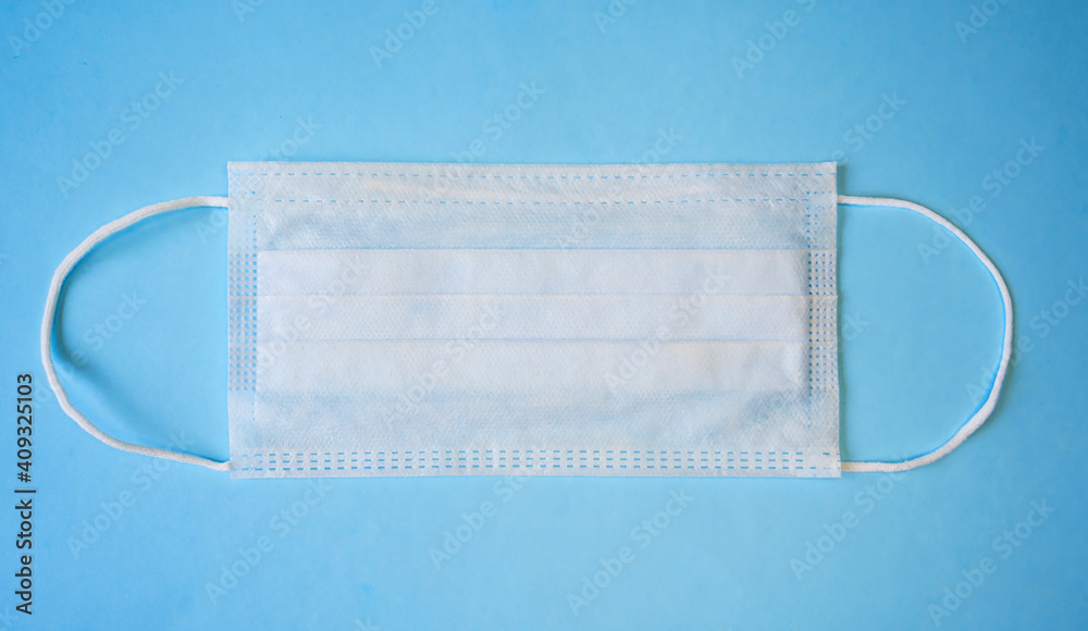 A single mask on a blue background. Medical concept. Protection from viruses. A single mask on a blue background. Medical concept. Protection from viruses.