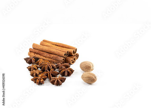 Seasoning for tea, anise stars with cinnamon sticks and nutmeg on a white background