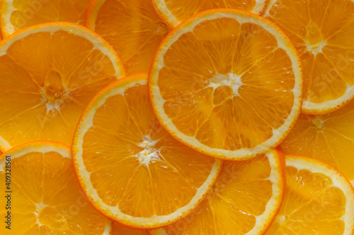 Sliced slices of fresh orange and laid out in the form of background close up. Flat view, healthy food. 