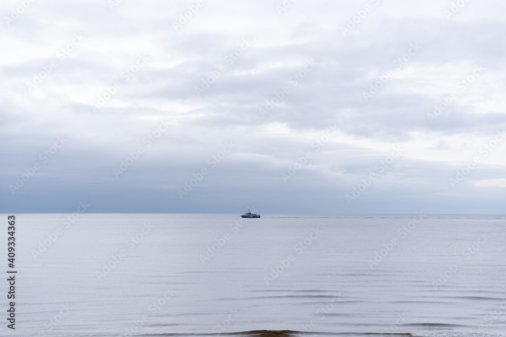the blue water of the Baltic Sea with a straight horizon where in the distance we can see the ship
