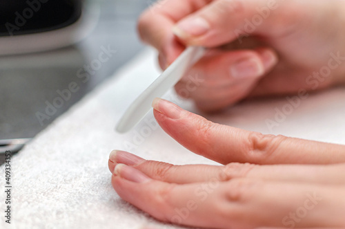 woman makes herself a manicure with a nail file at home