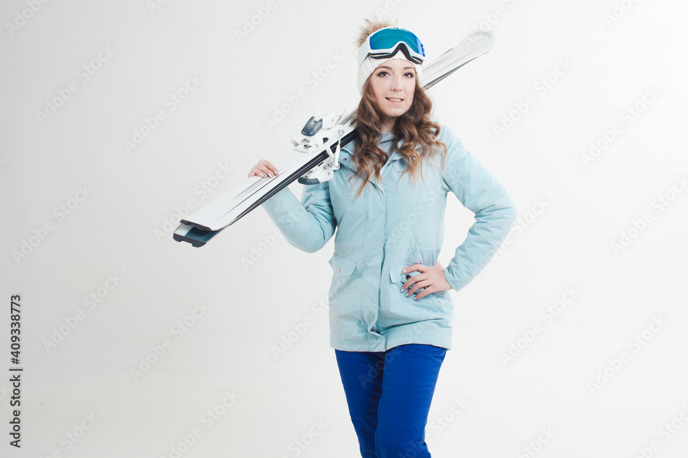 Smiling girl skier on a white background, portrait in the Studio. A young woman in winter clothes and ski equipment Smiling girl skier on a white background, portrait in the Studio. A young woman in winter clothes and ski equipment