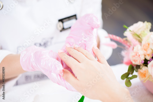Manicure master holding female hands in a beauty salon.