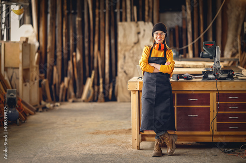 Positive woman working in joinery workshop photo