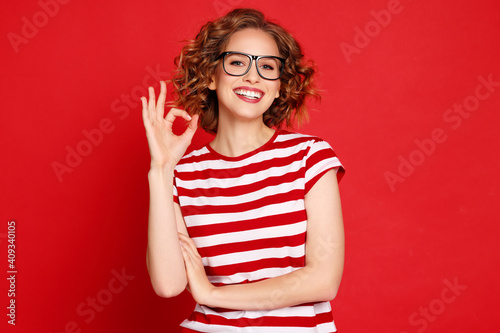 Delighted young woman gesturing OK
