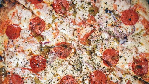 Close up of large pizza with different ingredients. Texture of appetizing pizza with various fillings.