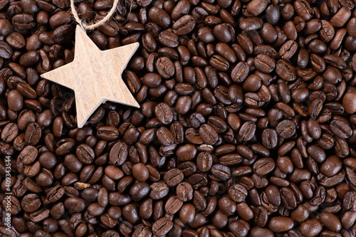Wooden star lying on coffee beans background