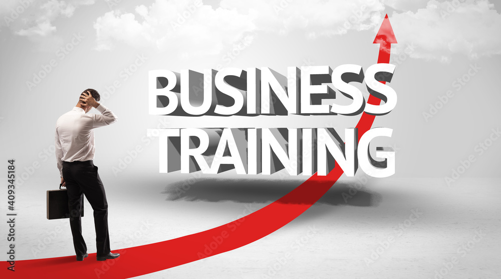 Rear view of a businessman standing in front of BUSINESS TRAINING inscription, successful business concept Rear view of a businessman standing in front of BUSINESS TRAINING inscription, successful business concept