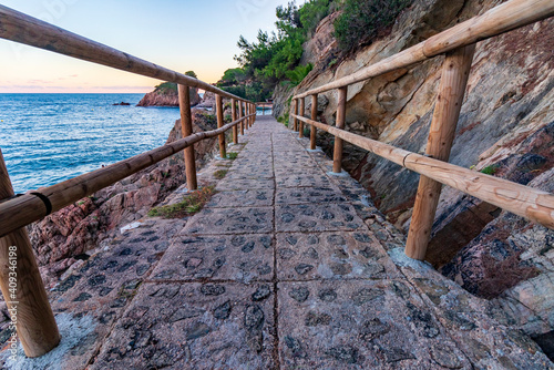 I walk along the coast with wooden railings at sunset photo