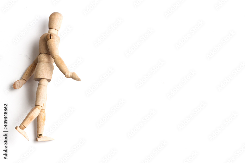 Wooden Mannequin on top of white table as if its walking and standing. Wooden Mannequin on top of white table as if its walking and standing.
