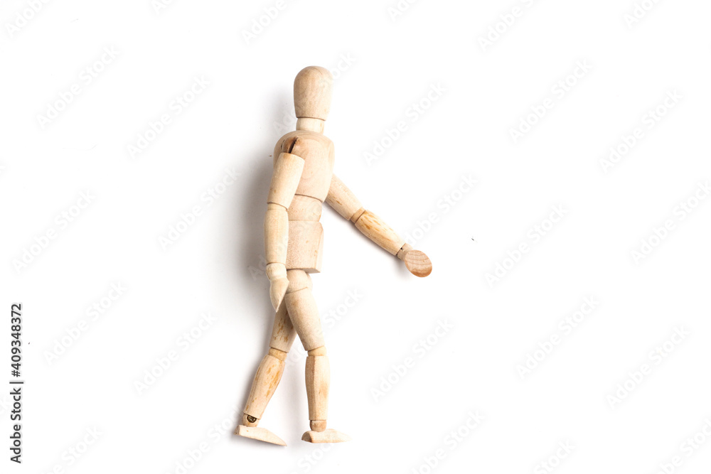 Wooden Mannequin on top of white table as if its walking and standing. Wooden Mannequin on top of white table as if its walking and standing.