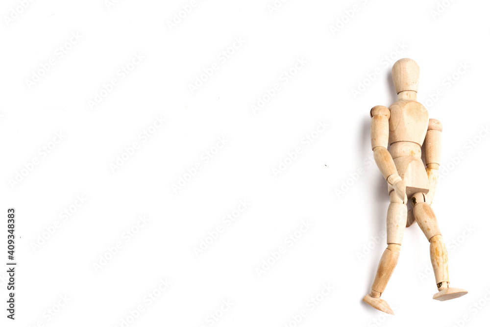 Wooden Mannequin on top of white table as if its walking and standing. Wooden Mannequin on top of white table as if its walking and standing.