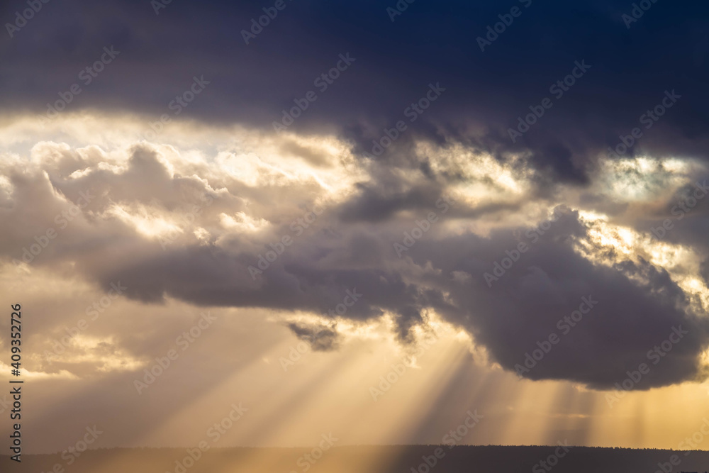 A dramatic sunset through the clouds over the ocean with rays of light