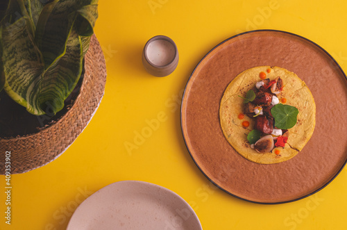 overhead photograph of single vegan taco on yellow background