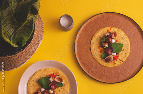 overhead photograph of half-eaten vegan tacos on yellow background