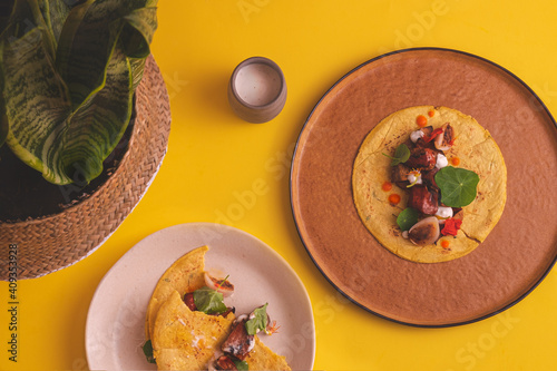 overhead photograph of half-eaten vegan tacos on yellow background