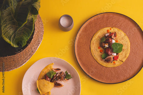 overhead photograph of half-eaten vegan tacos on yellow background