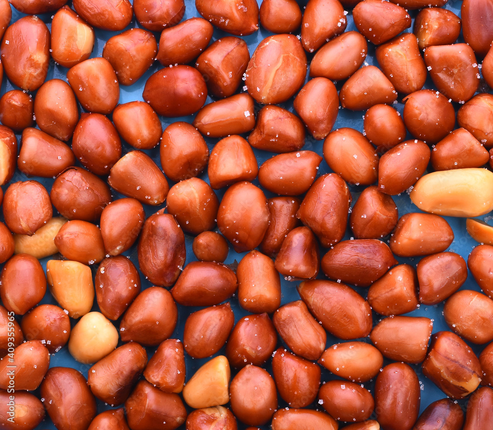 Macro flatlay image of roasted peanuts as a natural food pattern.