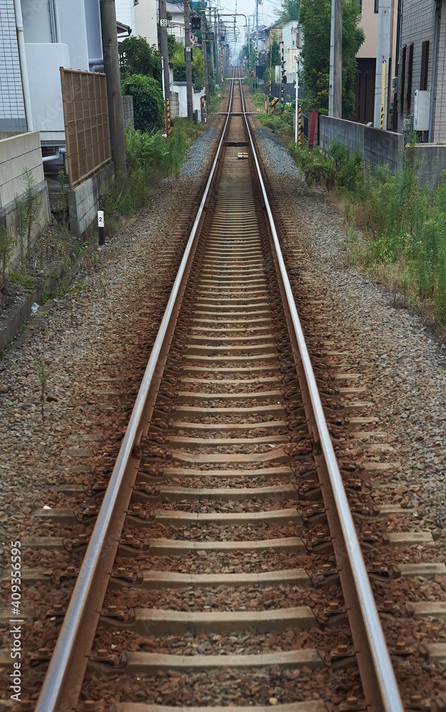 Naklejka premium 街の中を通るまっすぐな線路。鉄道のレール。
