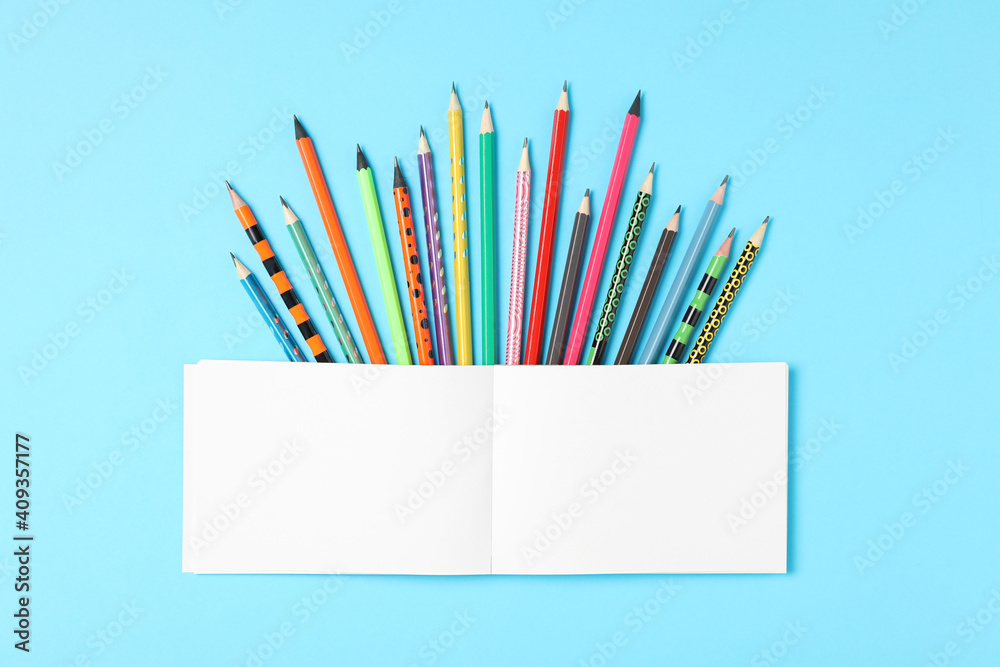 Different stationery and notebook on light blue background, flat lay with space for text. Back to school