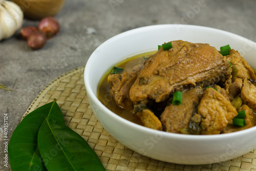 Semur Ayam Tahu, Indonesian traditional food made with chicken, tofu, spices, soy sauce and palm sugar. Grey grainy background, copy space for text. 