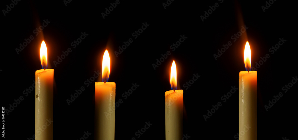 Arranged candles light with different heights burning brightly in the black background, blank and wide background. Arranged candles light with different heights burning brightly in the black background, blank and wide background.