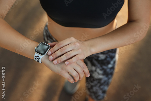 Woman using modern smart watch during training outdoors, above view