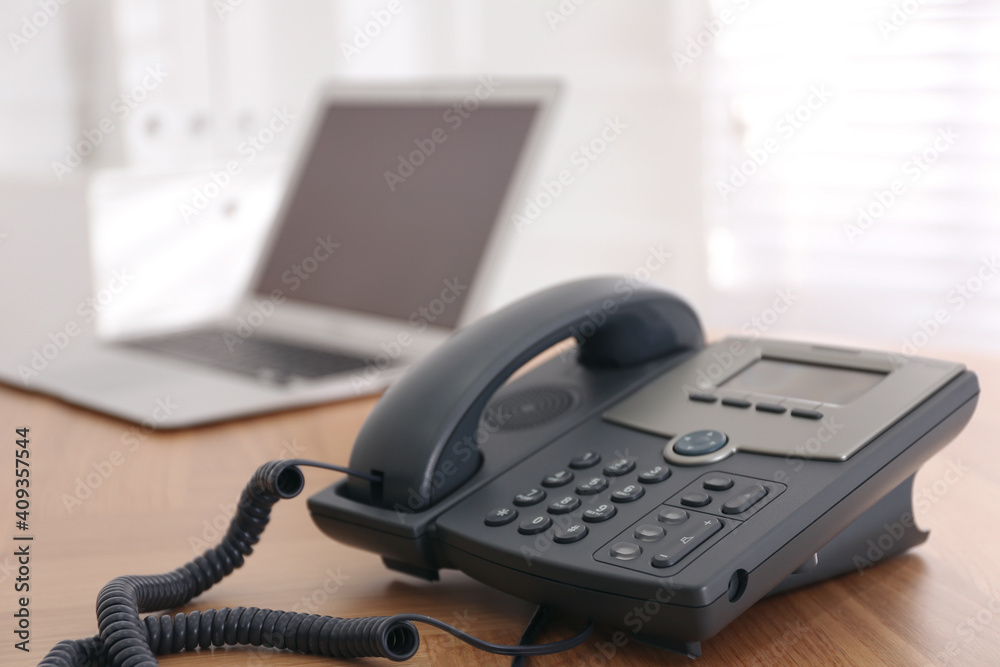 Stationary phone on wooden table indoors, space for text. Hotline service Stationary phone on wooden table indoors, space for text. Hotline service