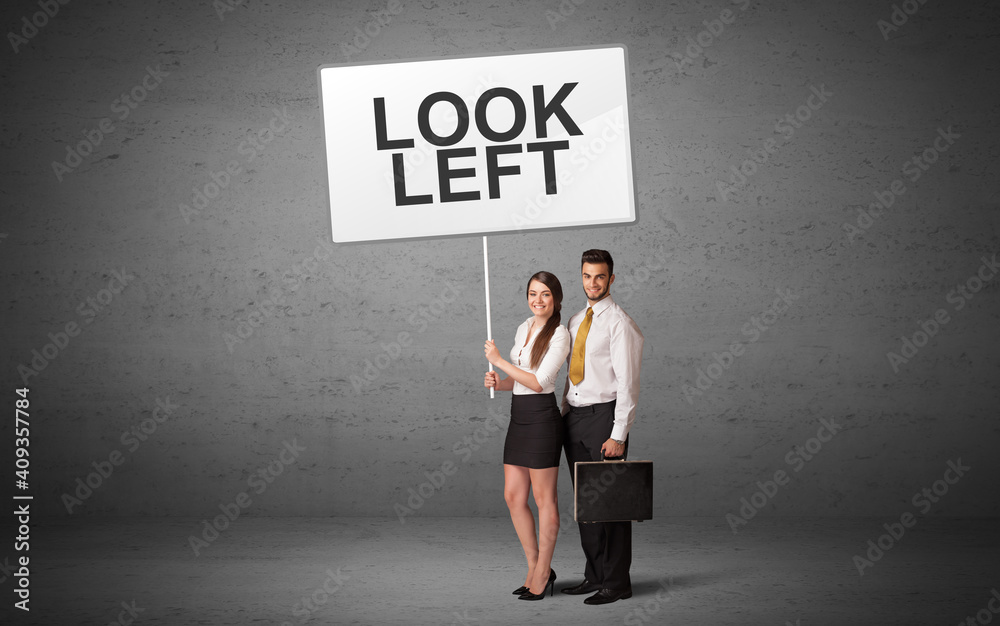 business person holding a traffic sign with LOOK LEFT inscription, new idea concept business person holding a traffic sign with LOOK LEFT inscription, new idea concept