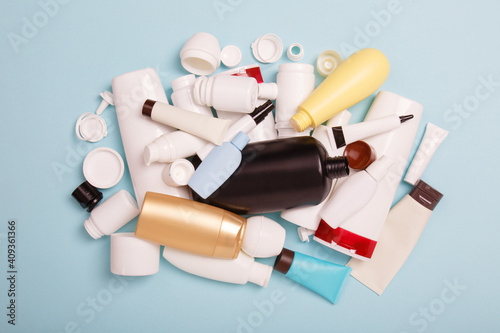 heap of separate collection of HDPE bottles from cosmetics for recycling. High-Density Polyethylene recyclable cosmetics package on blue background. Plastic garbage. Save the planet photo