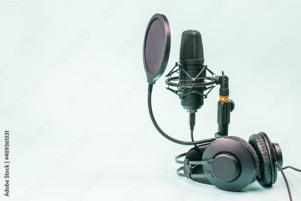 Black headphones and microphone with wires on a light blue background.