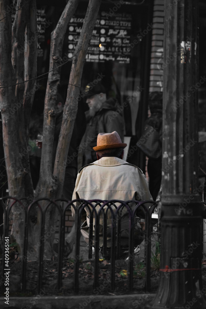 Elderly man sitting alone on bench.