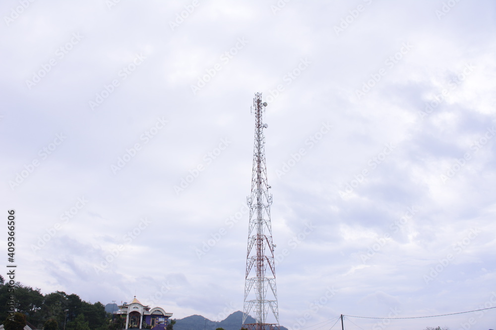 telecommunication tower against a background of cloudy sky.