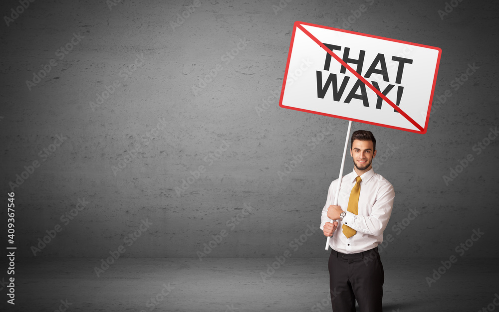 business person holding a traffic sign with THAT WAY! inscription, new idea concept business person holding a traffic sign with THAT WAY! inscription, new idea concept