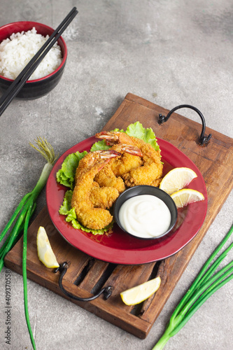 Ebi Furai or Tempura Shrimp or Prawn, Japanese Traditional Cuisine made from Deep Fried Shrimp Coated with Bread Crumb, served with mayounaise sauce, lemon slices, and a bowl of rice with chopstick.   photo