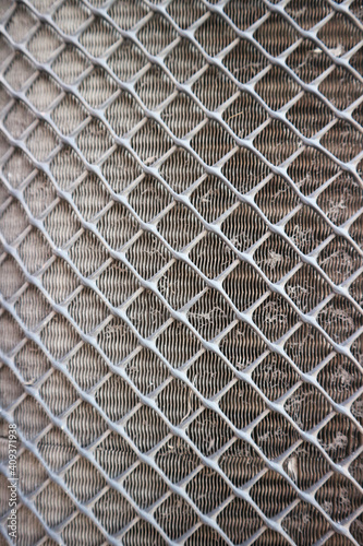 Gray steel grille beside the air conditioner fan 