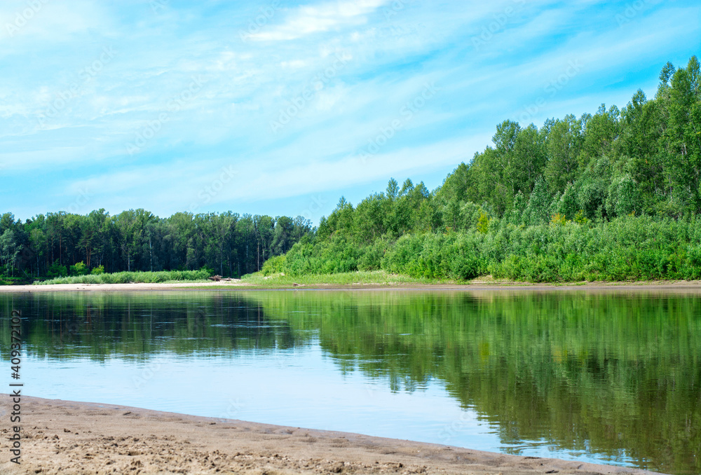 Blue sky on a calm summer day. Bend of the river in Siberia, forest near water