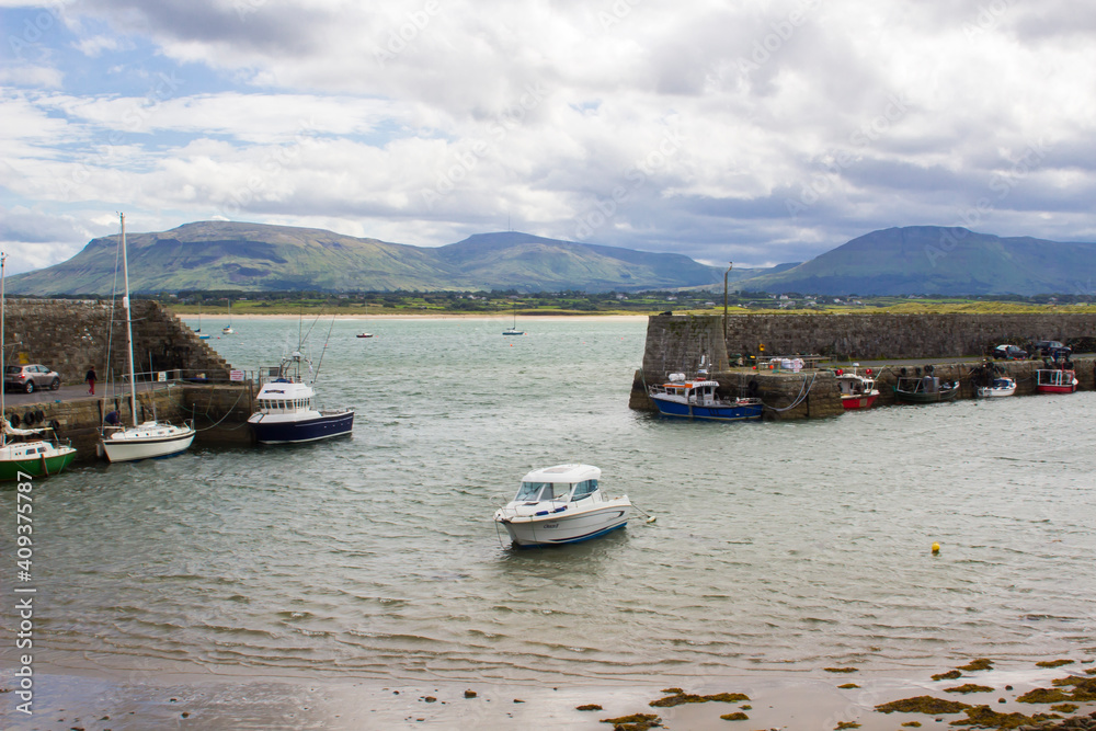Boats moored in the classic stone walled harbour in the small picturesque village of Mullaghmore in County Sligo on the West coast of Ireland Boats moored in the classic stone walled harbour in the small picturesque village of Mullaghmore in County Sligo on the West coast of Ireland
