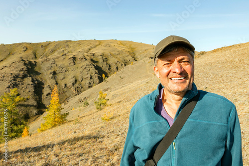 portrait of a mature tourist traveling along the Nurali ridge in the Ural mountains on an autumn sunny day. photo