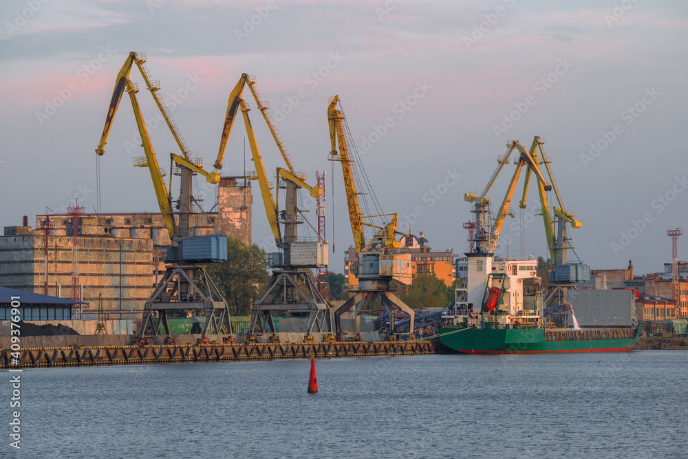 View of cargo port cranes October evening. Vyborg, Russia
